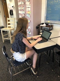 Student typing her poem on the computer.