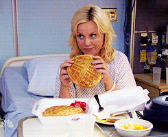 Leslie Knope in a hospital bed eats a waffle sadly