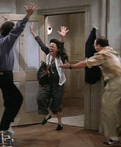Jerry, Elaine, and George from Seinfield raising their arms and tapping their feet in excitement.