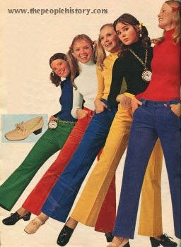 A 1971 photo of 5 women sticking out their leg while wearing either green, orange, blue, or yellow corduroy flared pants.