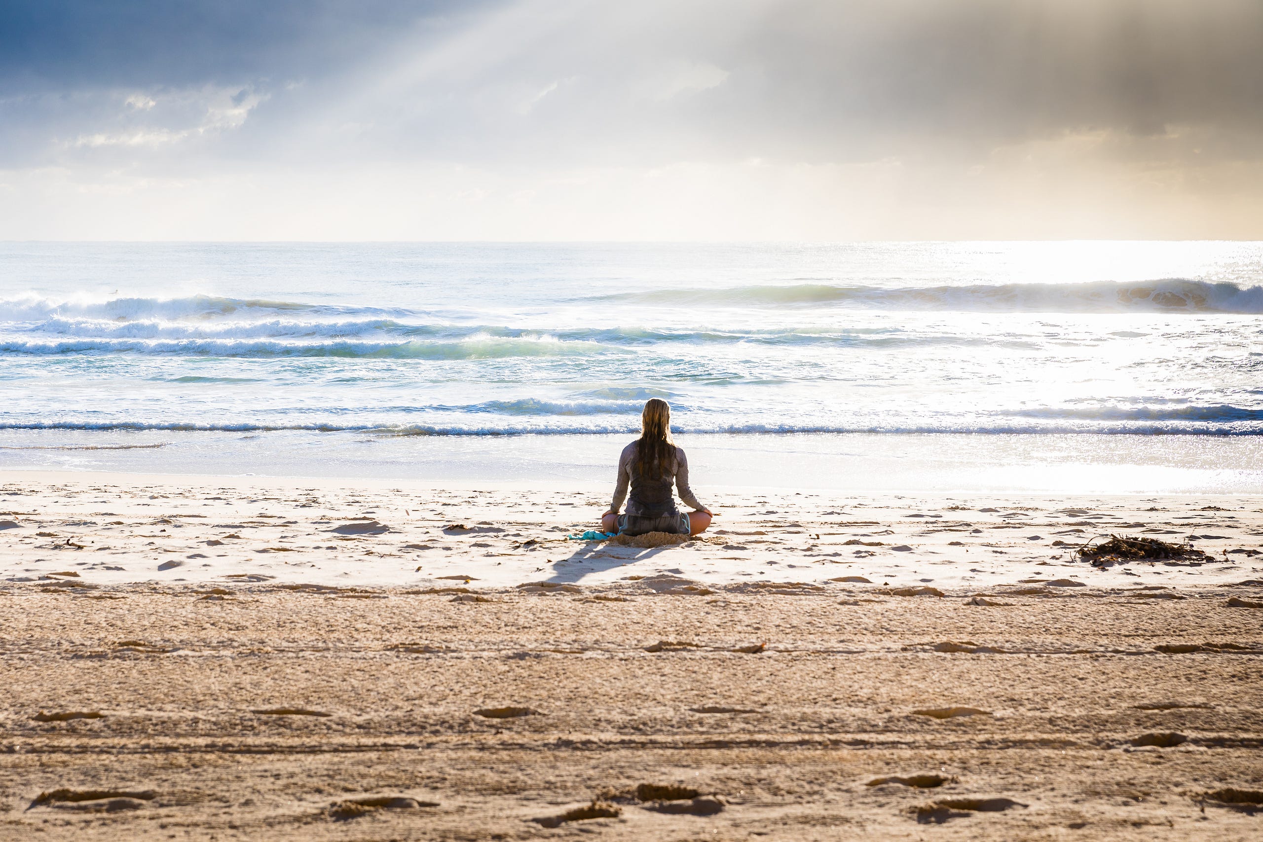 A person sitting on the beach meditating