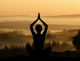 The silhouette of a young boy practicing meditation in a relaxed mental state