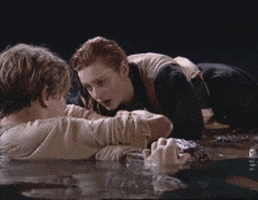 Animação em GIF mostrando cena do filme Titanic (1997) em que personagem Jack está em primeiro plano dentro do mar e a personagem Rose está sobre prancha de madeira falando com ele.