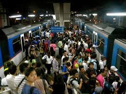 Two trains arriving at a crowded station