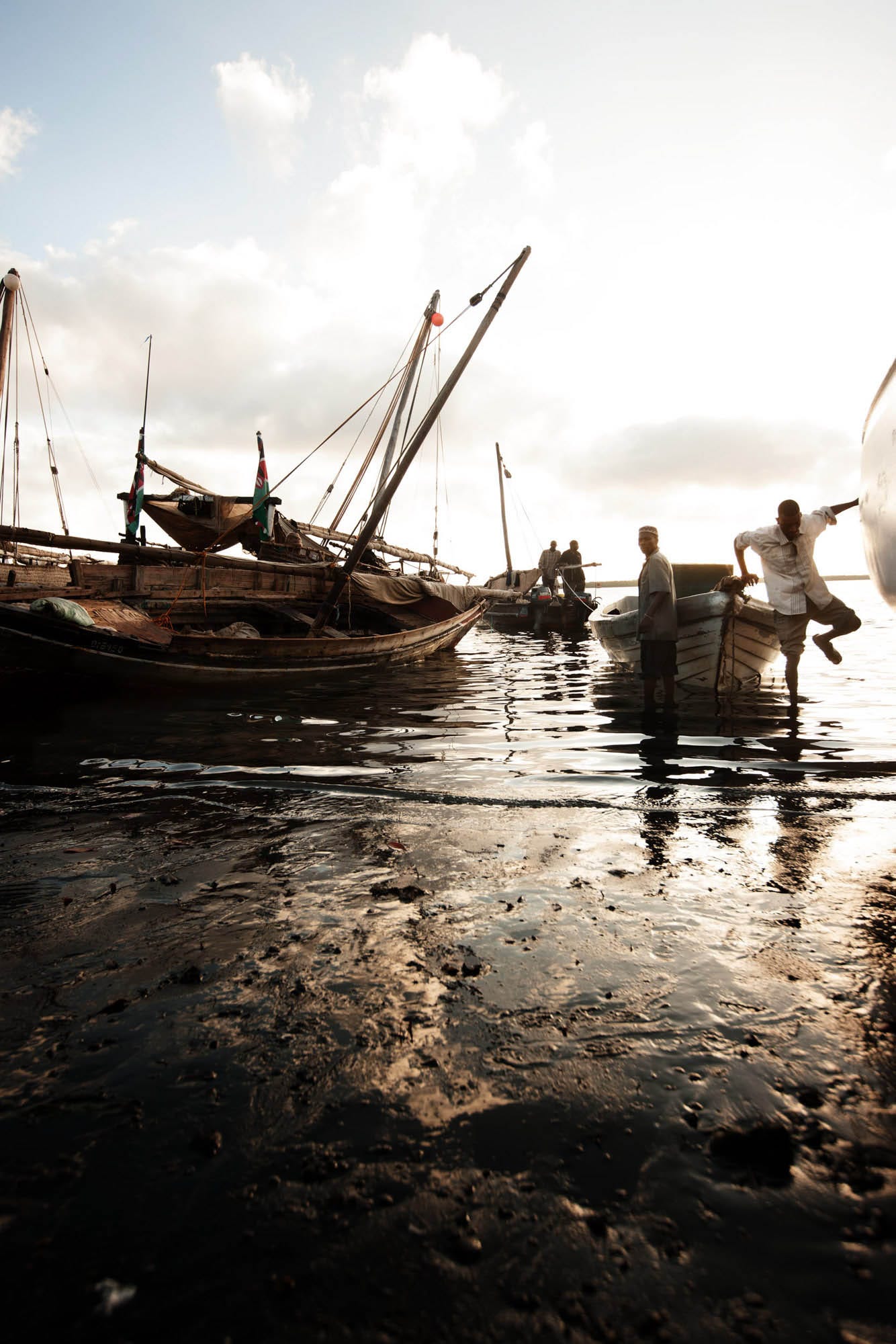 During low tide, fishing dhows keel over in the mud of the Lamu estuary. | © James Fisher 2017 All Rights Reserved.