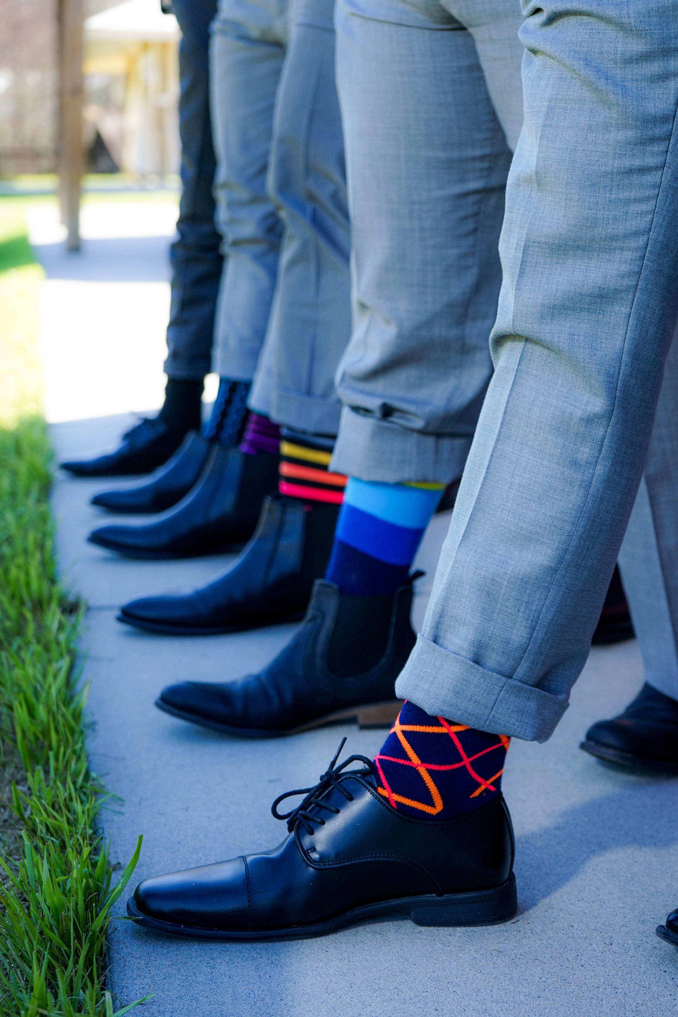 Men wearing odd socks in a line of feet