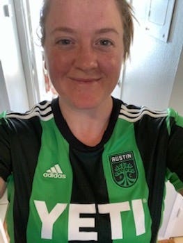 A picture of a smiling woman wearing the Austin FC jersey