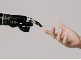 A robot and a human hand reaching for each other in a manner reminiscent of Michaelangelo’s The Creation of Adam.