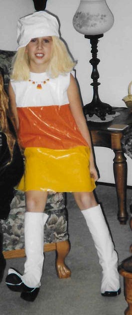 Me at 8 years old wearing a candy corn Halloween costume with knee-high go-go boots.