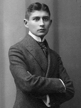 A fotografia em preto e branco é de Franz Kafka vestindo um terno. Seus braços estão cruzados, ele está virando contra a parede e olha para frente, porém não em direção da câmera.