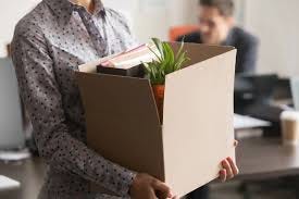woman carrying box, leaving her job