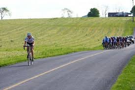 A solo breakaway, with cyclist pulling in front of the peloton.