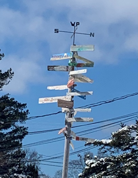 A sign post with arrows going in many directions.