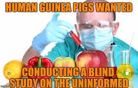 Meme of scientist injecting fruit with a syringe. Meme caption text: “Human guinea pigs wanted. Conducting a blind study on the uninformed.”