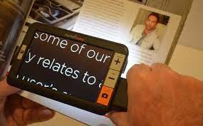 A person using digital magnifier to read a magazine