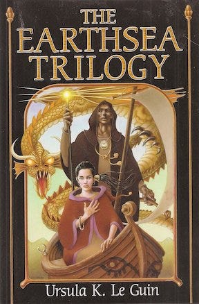 The cover of The Earthsea Trilogy depicting the characters Ged and Tenar and a dragon