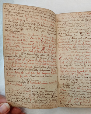 Double-page of handwritten medical recipes. The eighteenth-century handwriting is small with only a few gaps and coloured in both red and brown