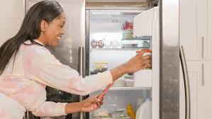 Woman taking a photo of items in the fridge.