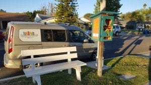 The Little Free Library outside of the Chadwick's home with The Literacy Club's van behind it.