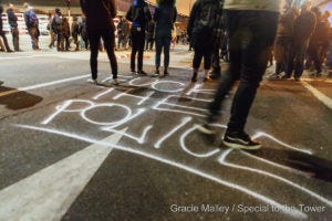 Protesters stand on a crowded Oakland street before heading to 880.