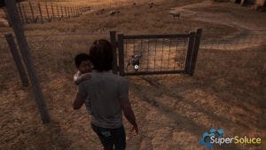 Ellie holds JJ as she looks at a fence.