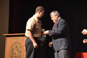 Cherokee senior, Michael Burris, is presented with his challenge coin as he heads off to the United States Navy by the LRHSD Board of Education during its 6th annual Armed Services Award Ceremony