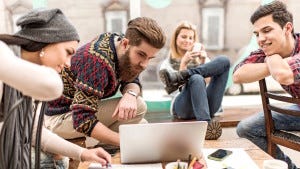 Team of creative people taking a break and using computer.