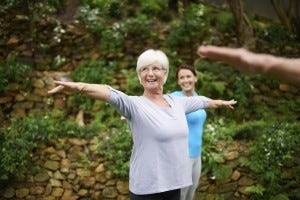 Shot of a senior woman enjoying an outdoor yoga class