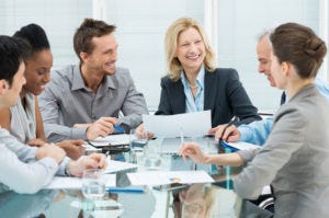 Group Of Happy Coworkers Discussing In Conference Room