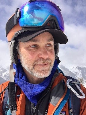 A headshot of a man hiking in snowy mountains