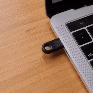 A person tapping a Yubikey to activate it.