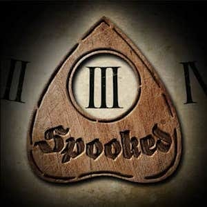 Ouija board centered on a III, with “Spooked” branded into the wood.