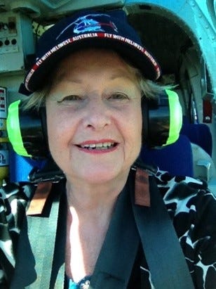 An image of the author, Lesley Dewar, as a helicopter pilot. She is wearing headphones and is strapped into the pilot’s seat.
