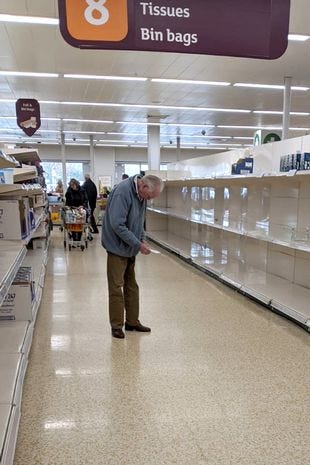 An elderly man standing in an empty toilet roll aisle in the supermarket Sainsbury’s, UK.