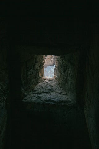 A small opening in a rock enclosure. Is it a hallway, a chimney, or simply a way out of self imprisonment?