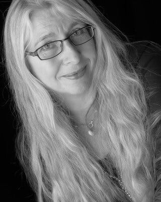 Black and white picture of a woman with long blond hair and glasses
