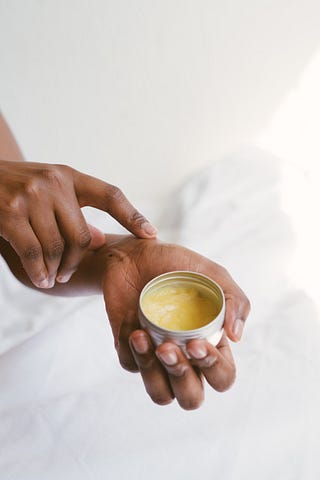 Woman applying shea butter to skin