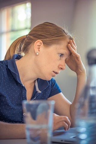 Worried woman looking at laptop