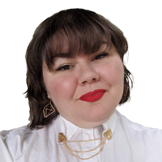 Sarah (she/her)—close photo of Latinx woman with tilted head and chin-length brown hair and bangs, red lipstick, dangly gold earrings, and a white top with a gold chain between collars.
