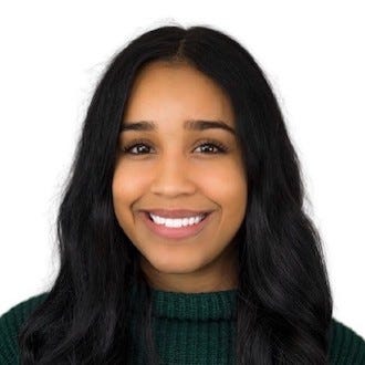 Shaylan (she/her)—close photo of smiling African-American woman with long, dark, wavy hair, and a dark green sweater.