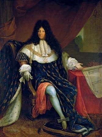 A painting of Louis XIV later in life, in luxurious velvet and fur robes and a cape, sitting a table. He wears a large and long black curly wig.