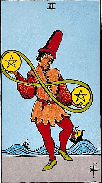 Two of Pentacles — A man juggles two pentacles, one in each hand. there is a ribbon around them that looks like an infinity symbol