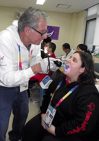 Dr. Steve Perlman conducts a health screening for Special Olympics Spain athlete Leyre Buigues during the 2013 Special Olympics World Winter Games.