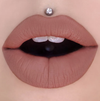 A semi-opened mouth with Jeffree Star’s liquid lipstick in the color Celebrity Skin (creamy brown) on the lips.