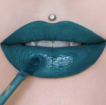 A semi-opened mouth with Jeffree Star’s liquid lipstick in the color Mermaid Blood (dark teal) on the lips.