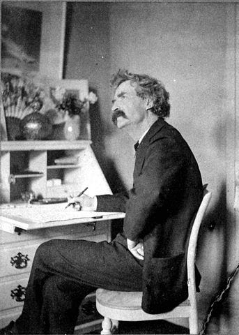 Mark Twain writes at his desk