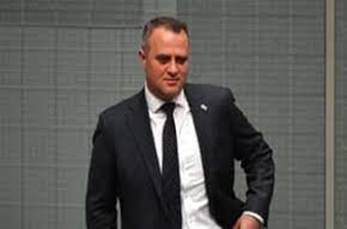 Tim Wilson, Coalition MP for Goldstein stands wearing a black suit with a white shirt