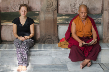 In this image it is the lay person on the left who appears to be meditating, and not the monk on the right, who is reading.(Ghosh/Tapasphotography/flickr).