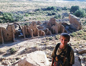 young boy standing in front of Chaco Canyon Ruins