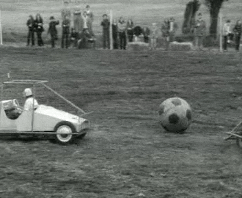 An animated GIF of a football/soccer match played by players riding cars